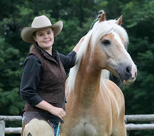 A horse trainer standing next to a palomino